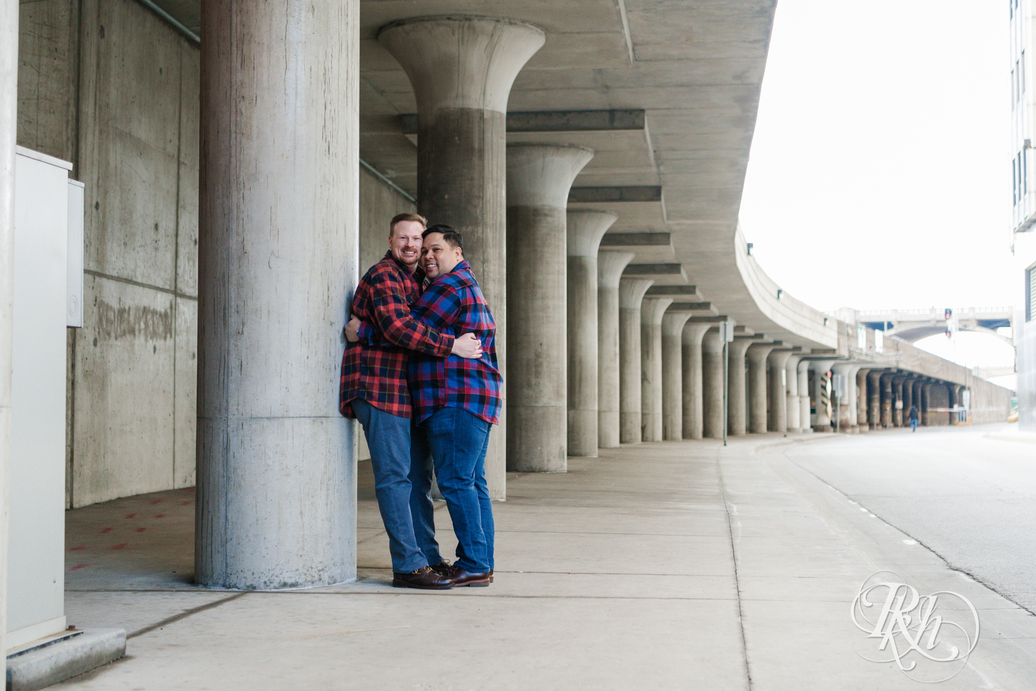 Two gay men in flannels smile near Union Depot in Saint Paul, Minnesota.