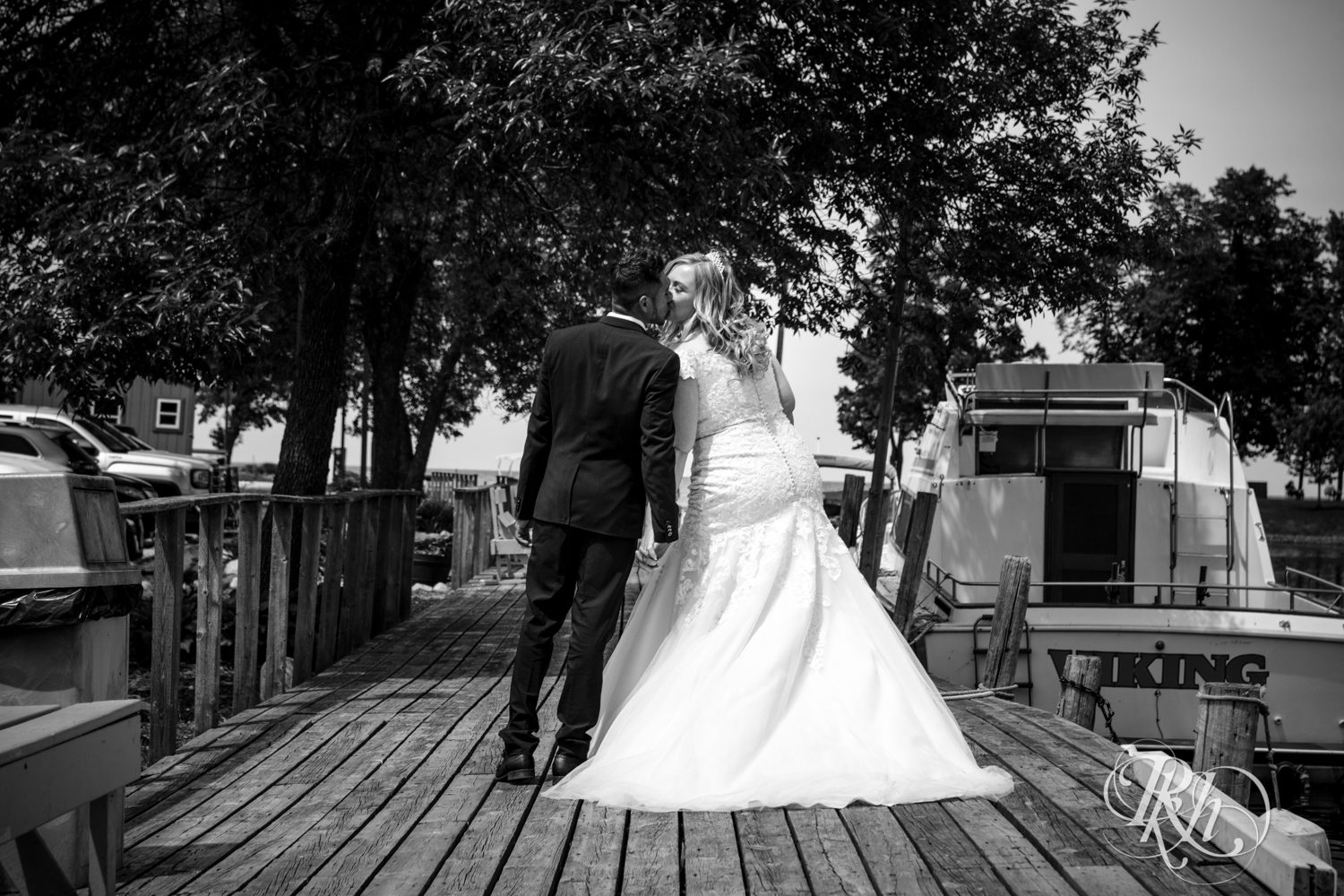 Bride and groom kiss on a dock at Izatys Resort in Onamia, Minnesota.