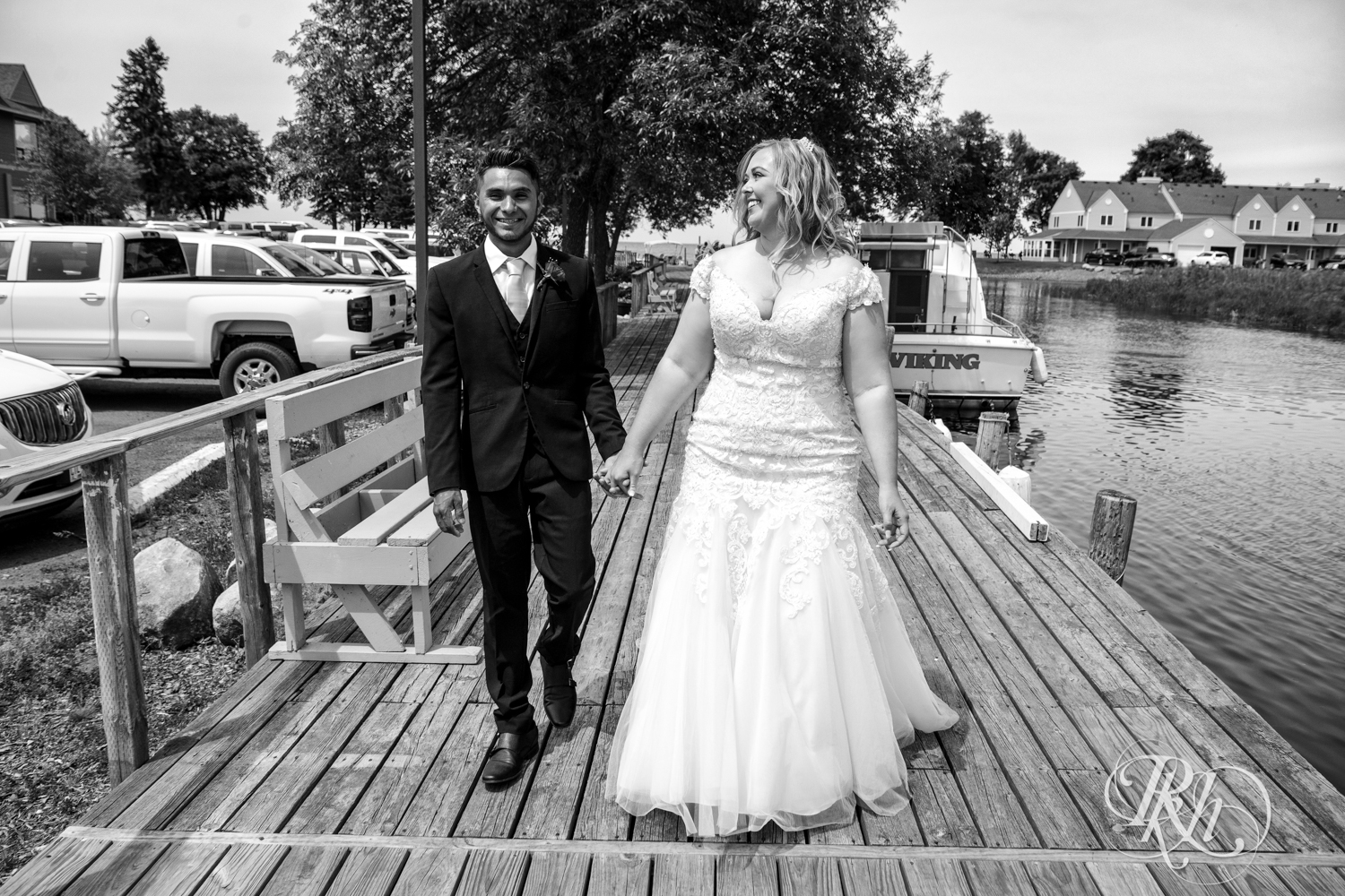 Bride and groom walk on a dock at Izatys Resort in Onamia, Minnesota.