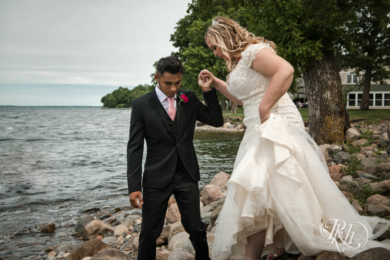 Bride and groom walk in front of Lake Mille Lacs at Izatys Resort in Onamia, Minnesota.