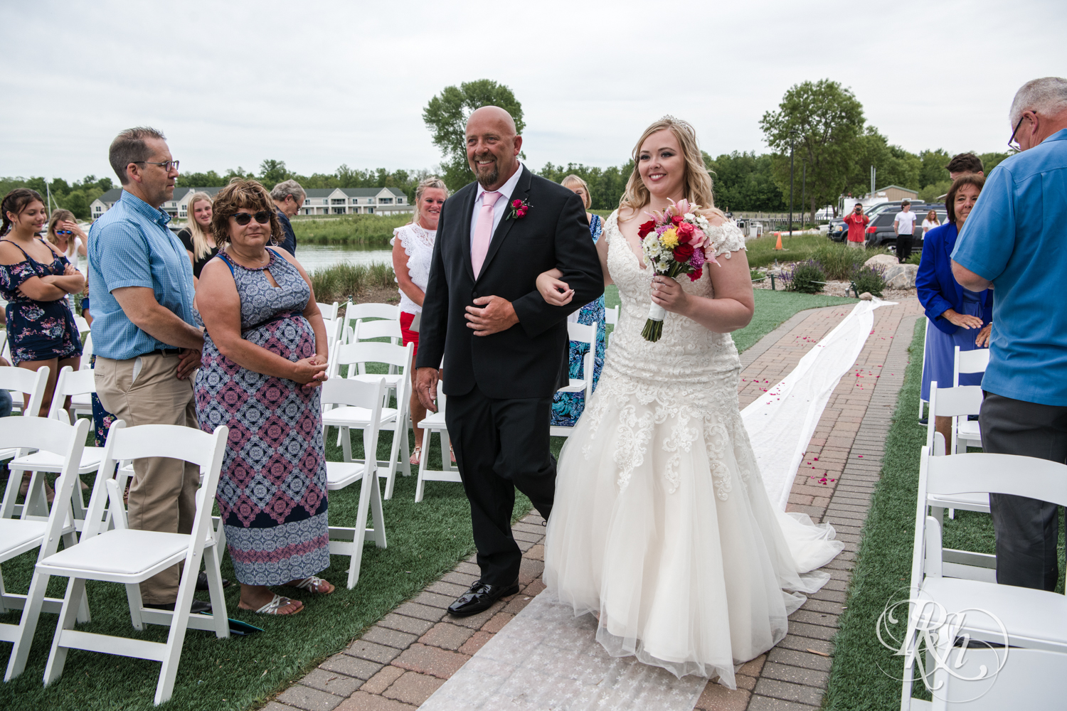 Bride walks down the aisle with dad at wedding ceremony at Izatys Resort in Onamia, Minnesota.