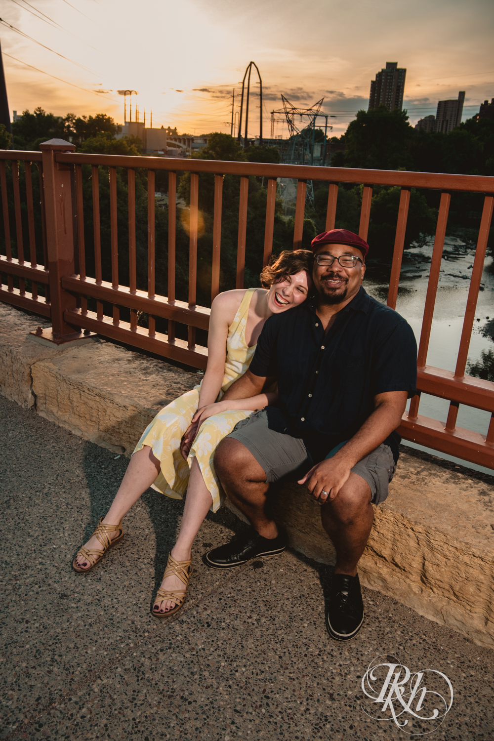 Black man and woman laugh at sunset on Stone Arch Bridge in Minneapolis, Minnesota.