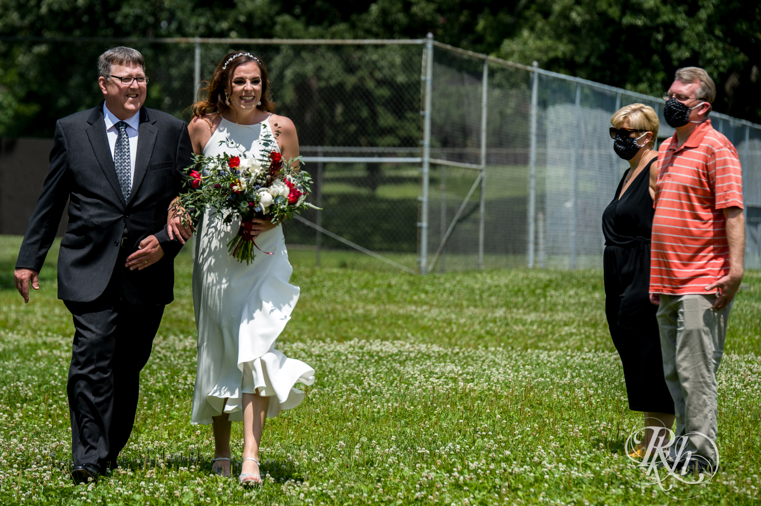 Bride walks down the aisle with her dad in Loring Park in Minneapolis, Minnesota.