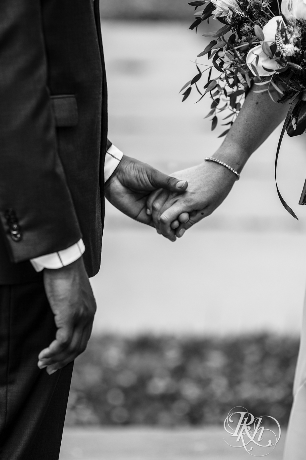 Black man and woman biracial couple hold hands during wedding ceremony in Loring Park in Minneapolis, Minnesota.