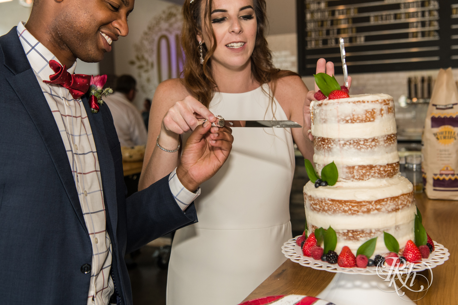 Black man and woman biracial couple cut cake at wedding reception in Minneapolis, Minnesota.