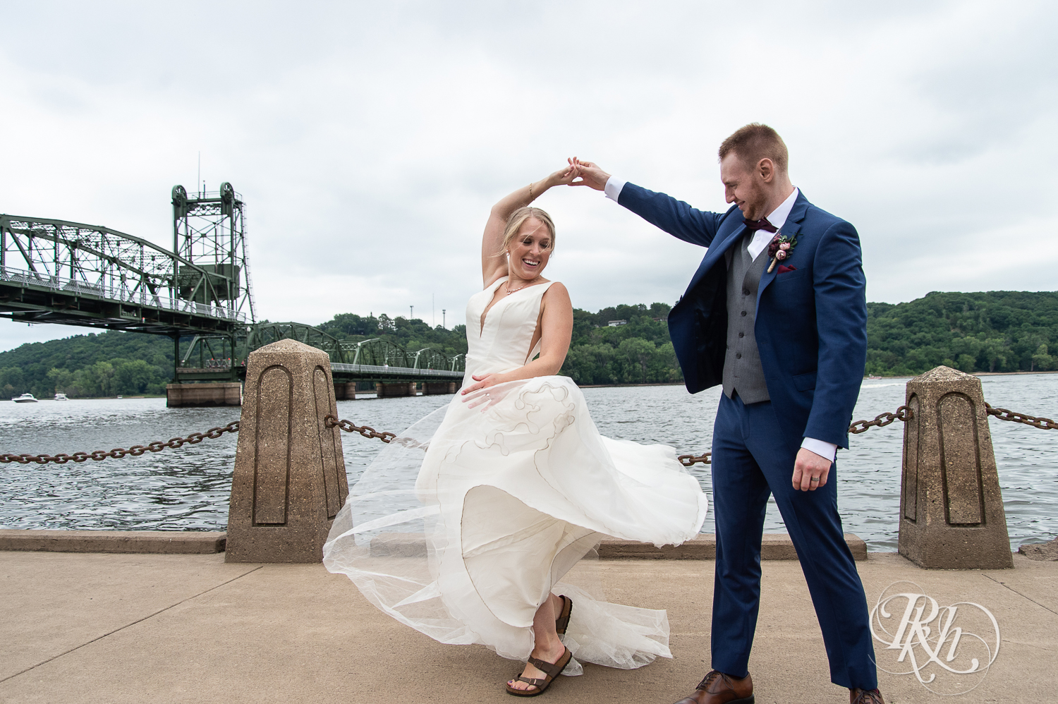 Bride and groom dance in front of St. Croix River in Stillwater, Minnesota.
