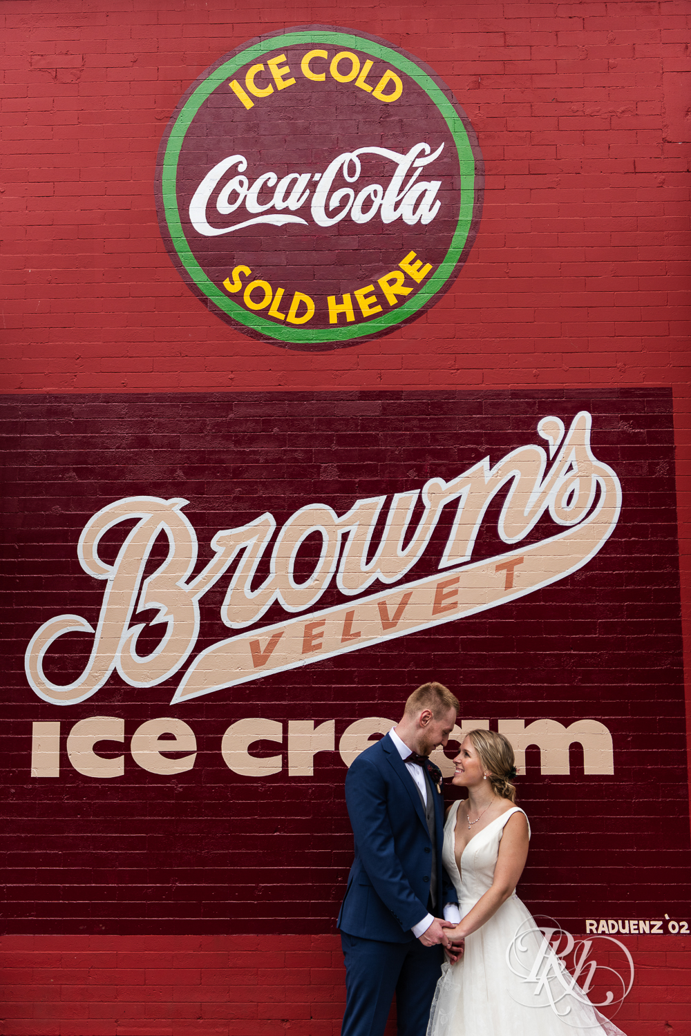 Bride and groom smile in front of Brown's Velvet Ice Cream in Stillwater, Minnesota.