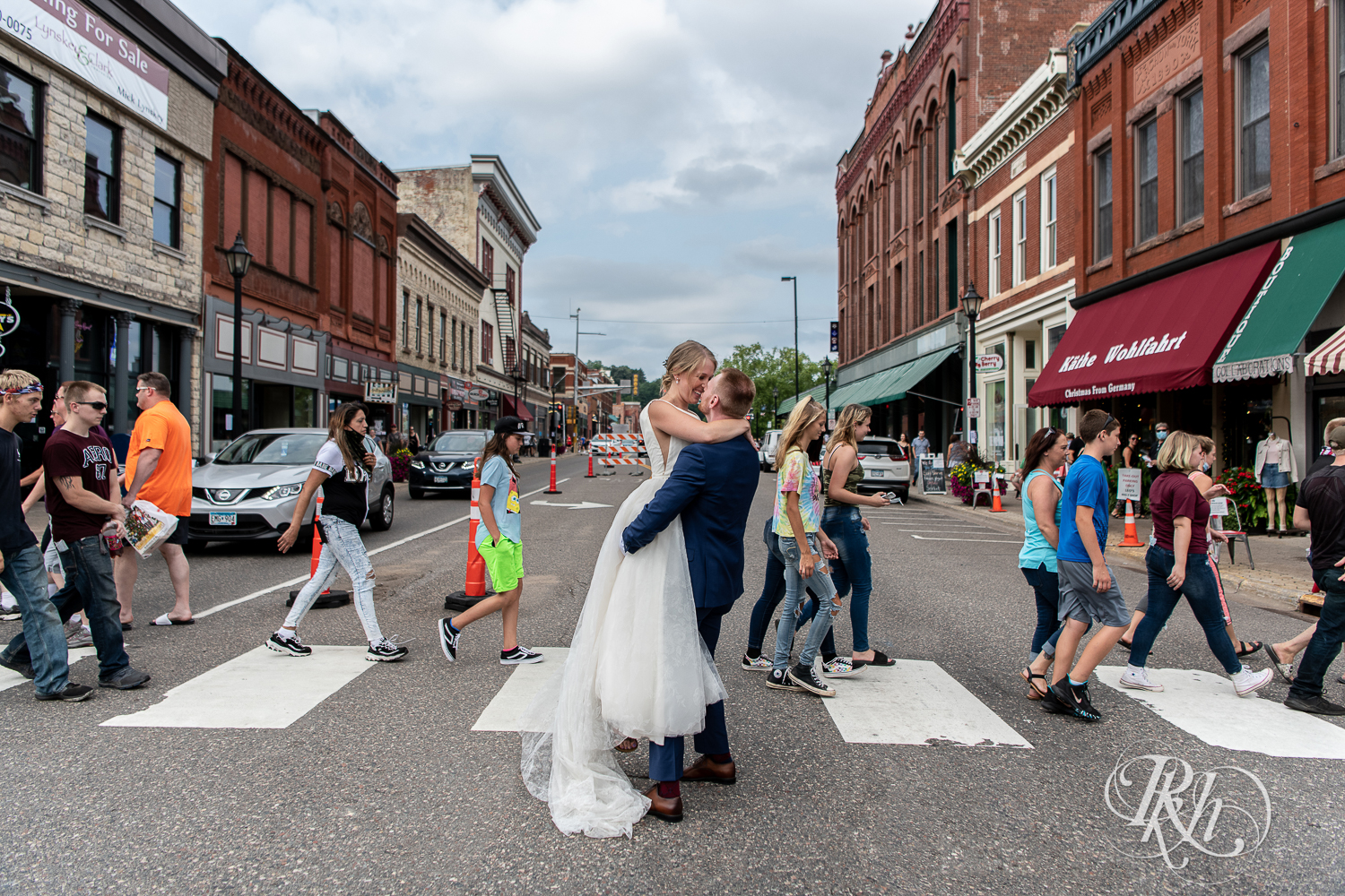 Bride and groom kiss in city street in Stillwater, Minnesota.