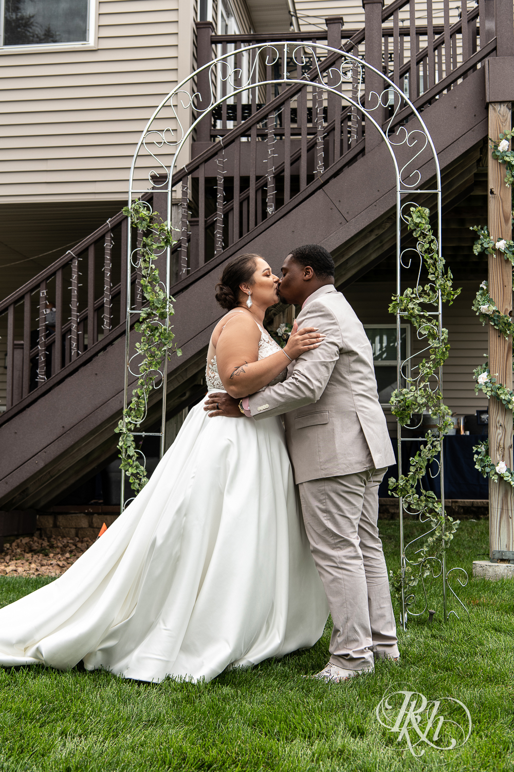 Black bride and groom kiss at wedding ceremony at home wedding in Brooklyn Park, Minnesota.