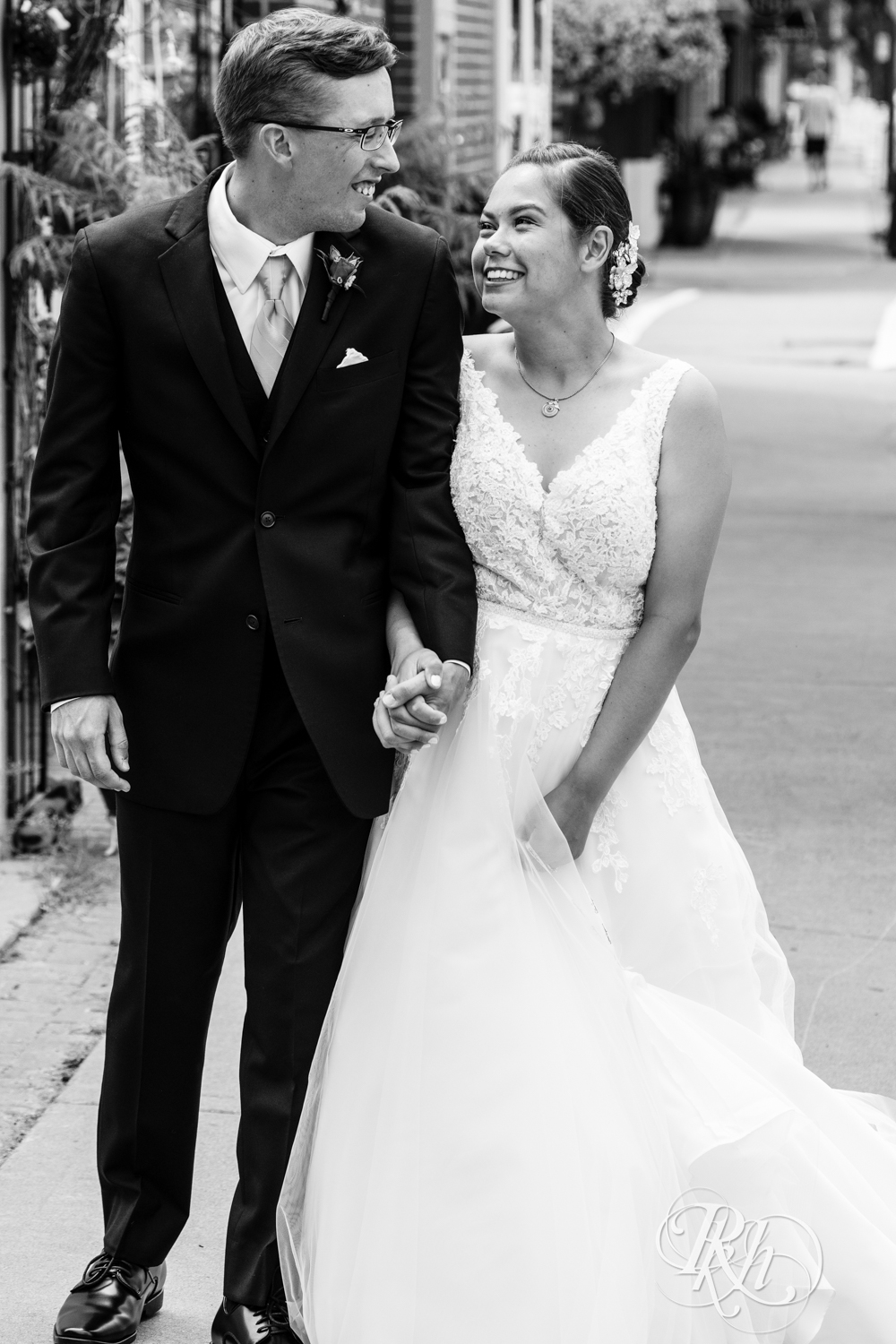 Bride and groom walk down the city street in White Bear Lake, Minnesota.