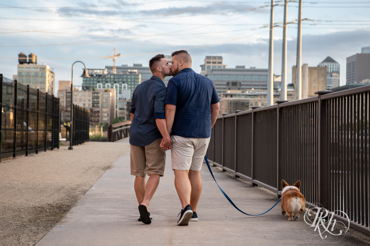 Two gay men kiss while walking their Corgi in Minneapolis, Minnesota.