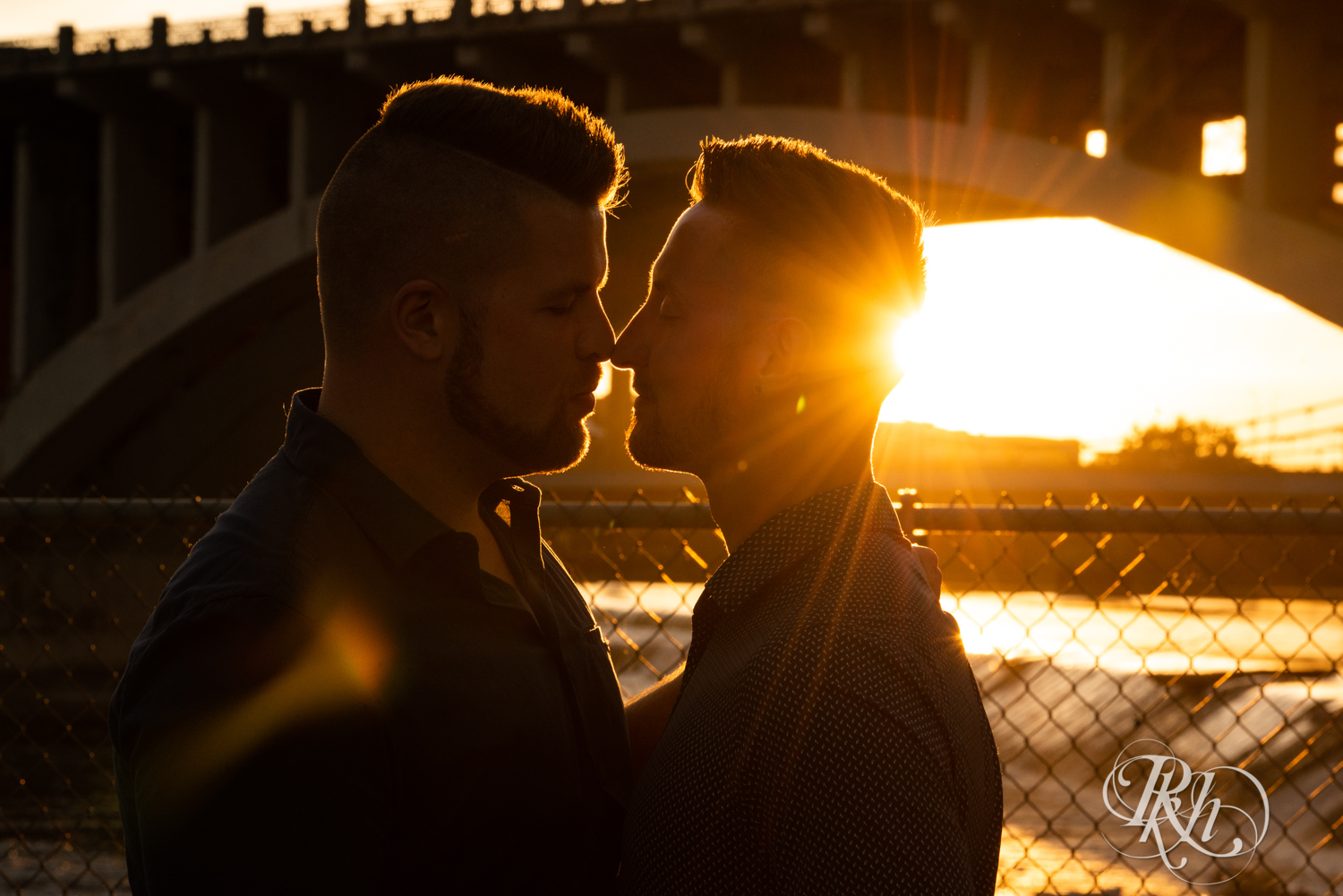 Two gay men kiss during sunset in Saint Anthony Main in Minneapolis, Minnesota.