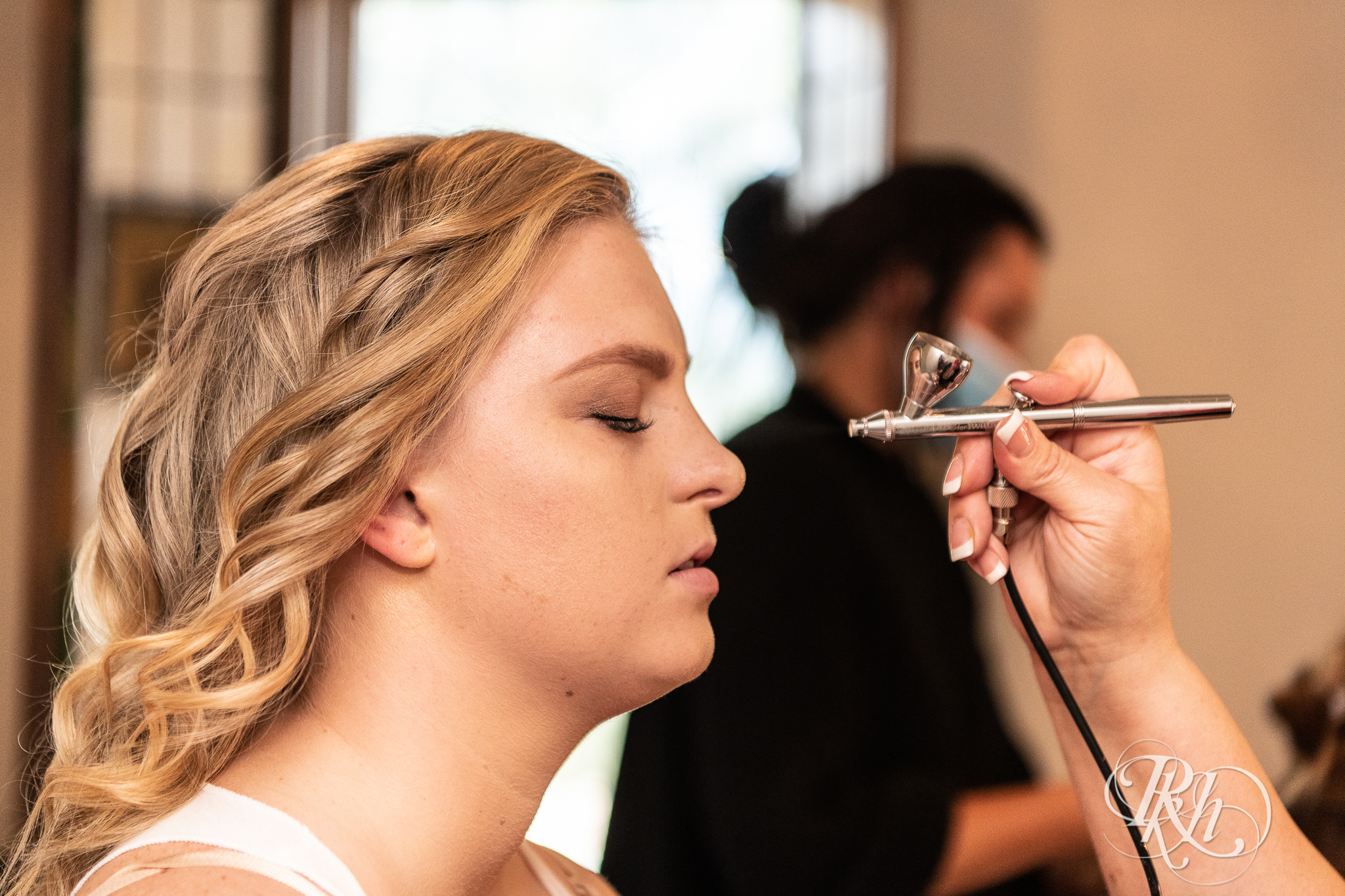 Bride getting makeup done before wedding at Weddings at the Broz in New Prague, Minnesota.