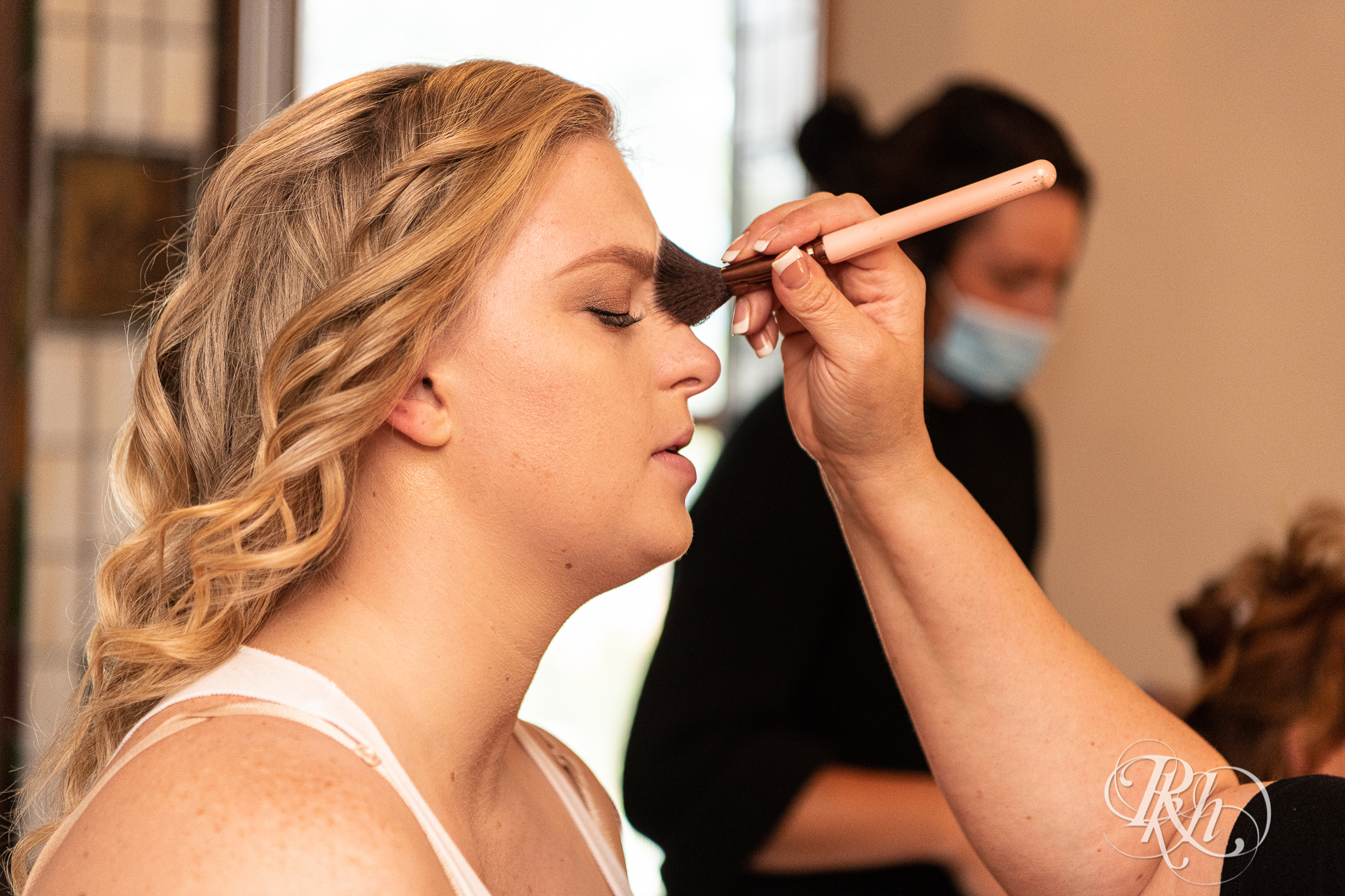 Bride getting makeup done before wedding at Weddings at the Broz in New Prague, Minnesota.