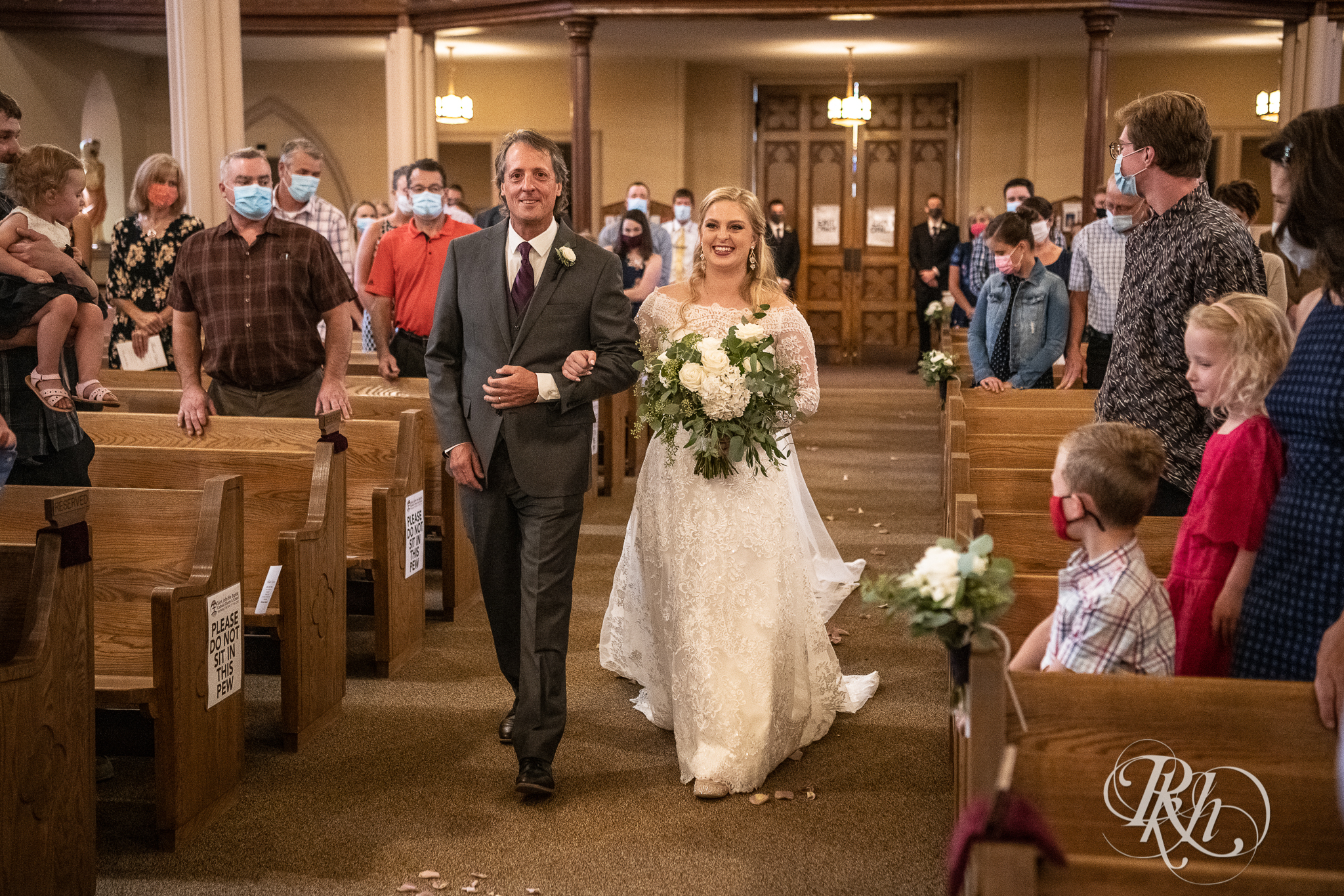 Bride walking down the aisle with her dad at church wedding in New Prague, Minnesota.