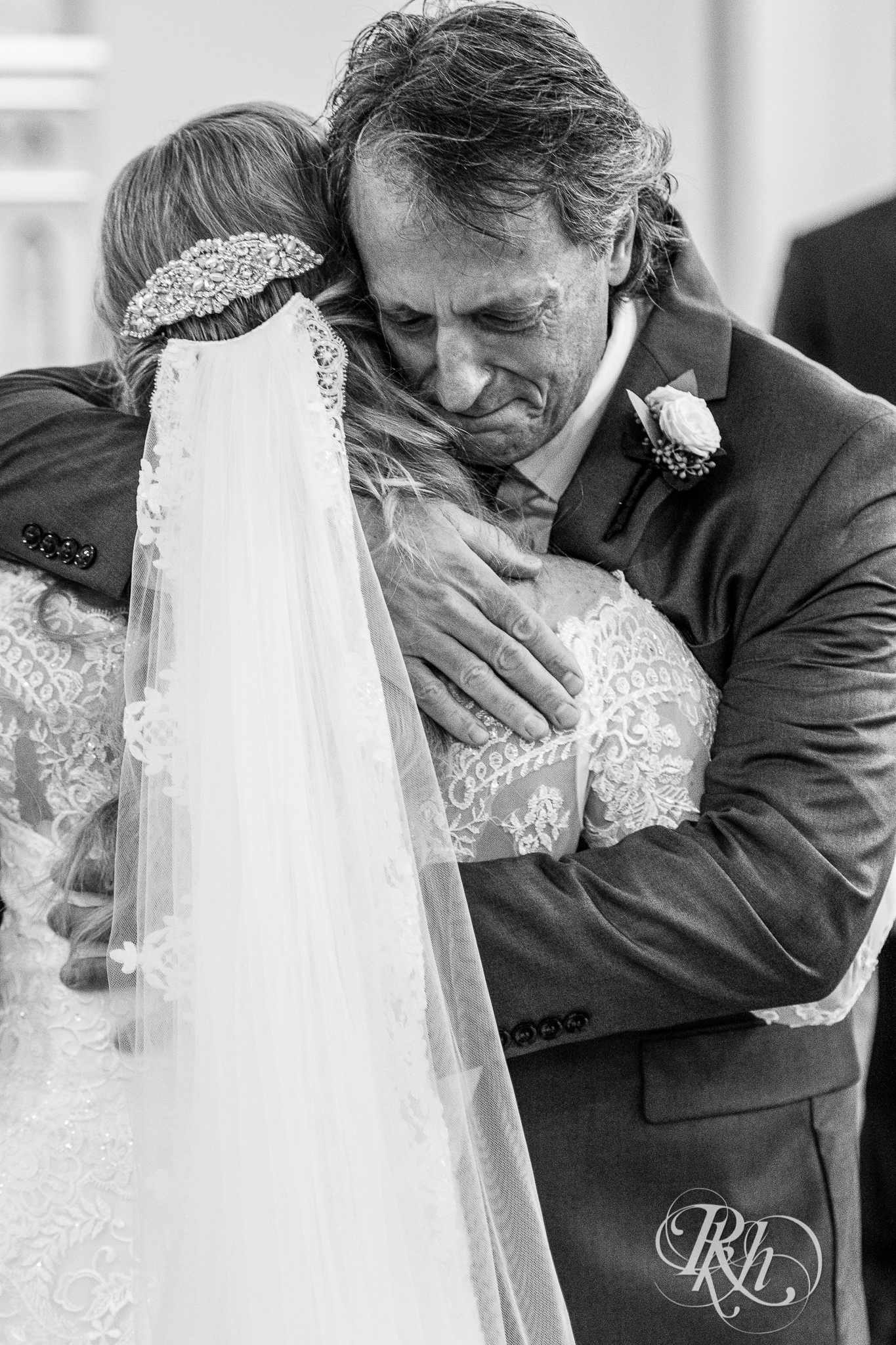 Dad hugging bride at alter at church wedding in New Prague, Minnesota.