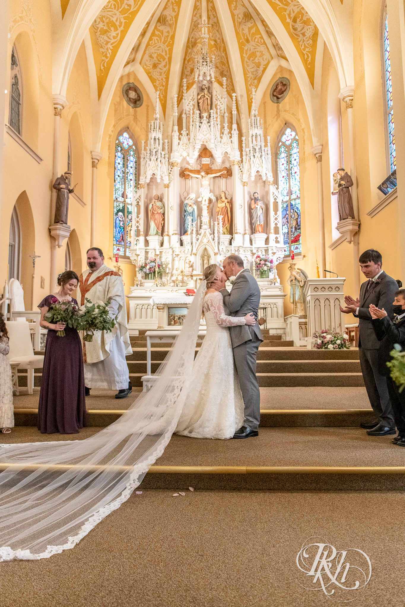 Bride and groom kiss at church wedding in New Prague, Minnesota.