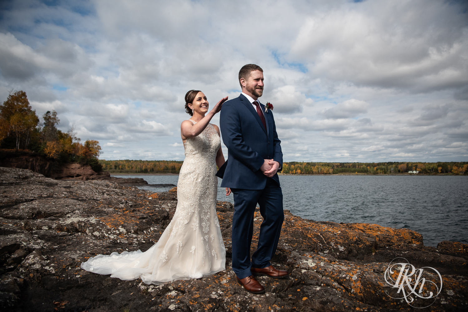 Bride and groom share first look on rock in front of Lake Superior at Superior Shores Resort in Two Harbors, Minnesota.