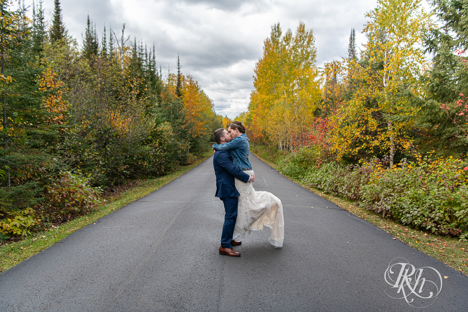 Groom lifts and kisses bride at Superior Shores Resort in Two Harbors, Minnesota.