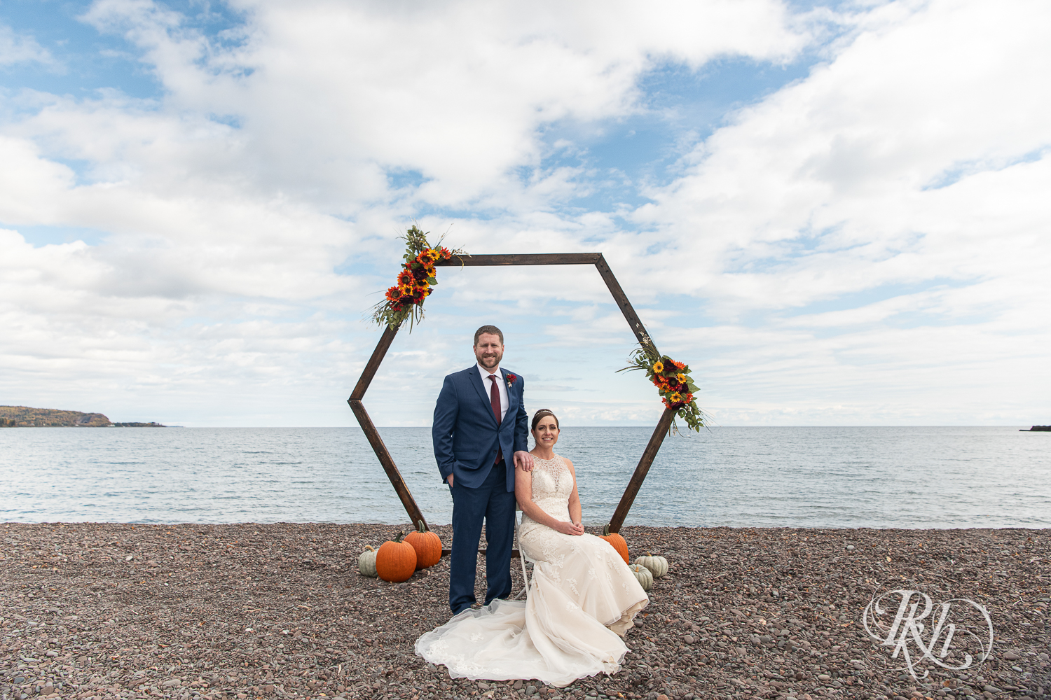 Bride and groom smile in front of Lake Superior at Superior Shores Resort in Two Harbors, Minnesota.