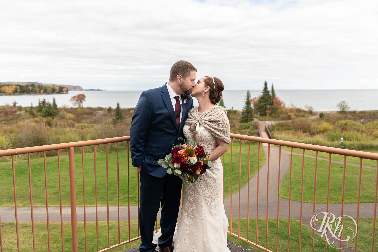 Bride and groom kiss on balcony at Superior Shores Resort in Two Harbors, Minnesota.