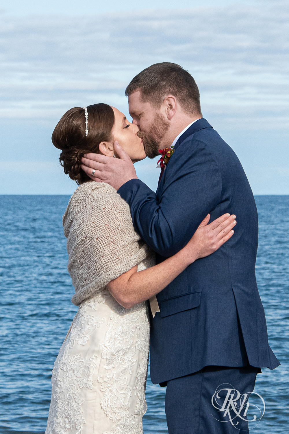 Bride and groom kiss in front of Lake Superior at Superior Shores Resort in Two Harbors, Minnesota.