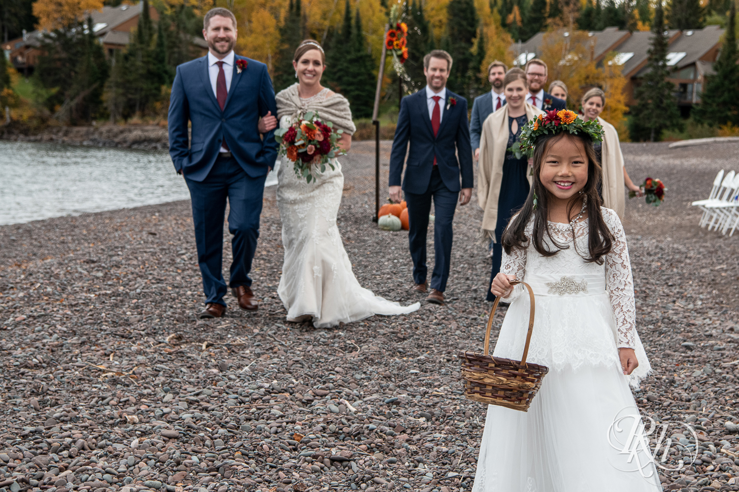 Wedding party walking behind flower girl in front of Lake Superior at Superior Shores Resort in Two Harbors, Minnesota.