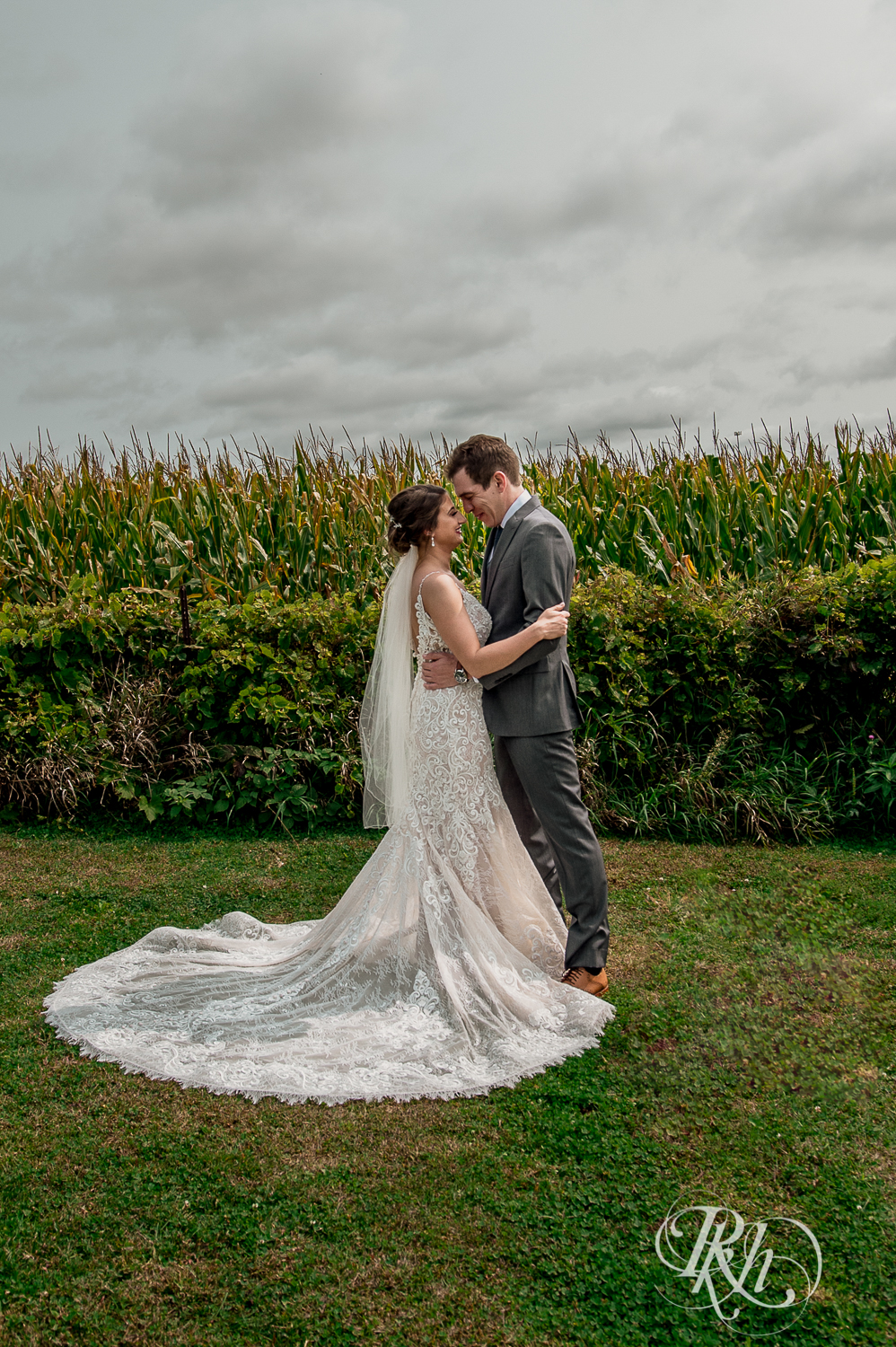 Bride and groom smile in front of cornfield at Legacy Hills Farm in Welch, Minnesota.