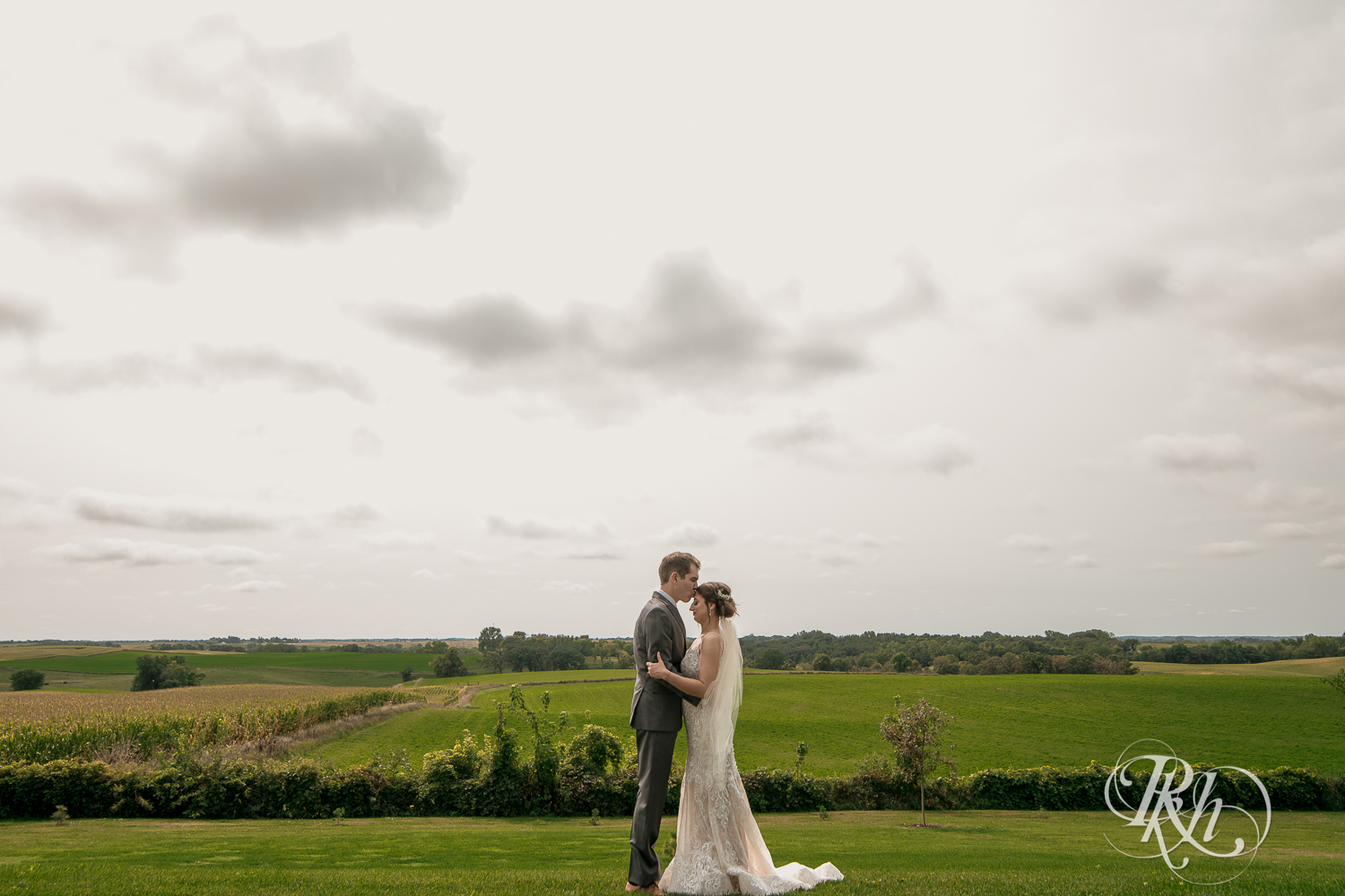 Bride and groom kiss on hill at Legacy Hills Farm in Welch, Minnesota.