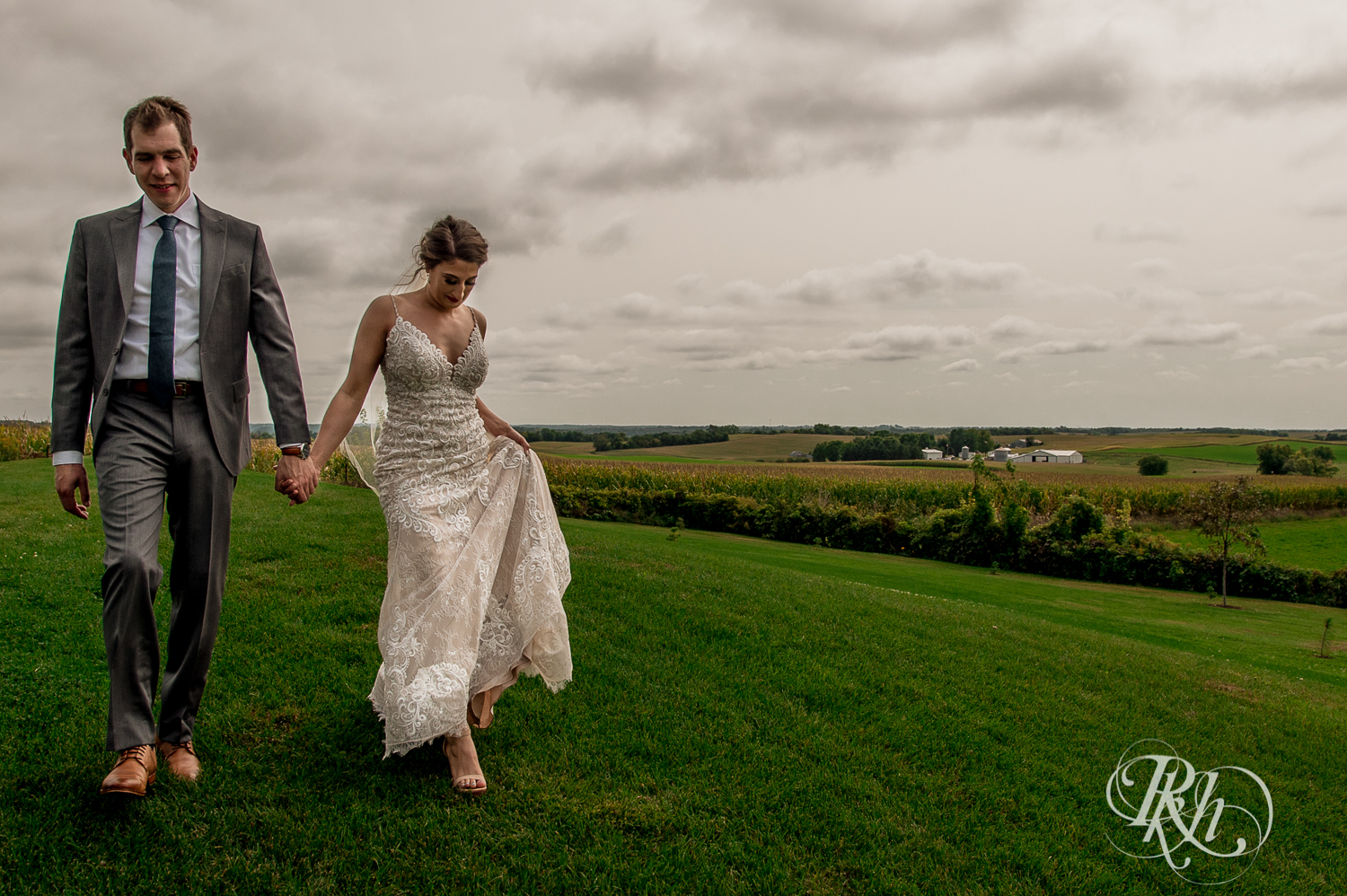 Bride and groom walk on hill at Legacy Hills Farm in Welch, Minnesota.