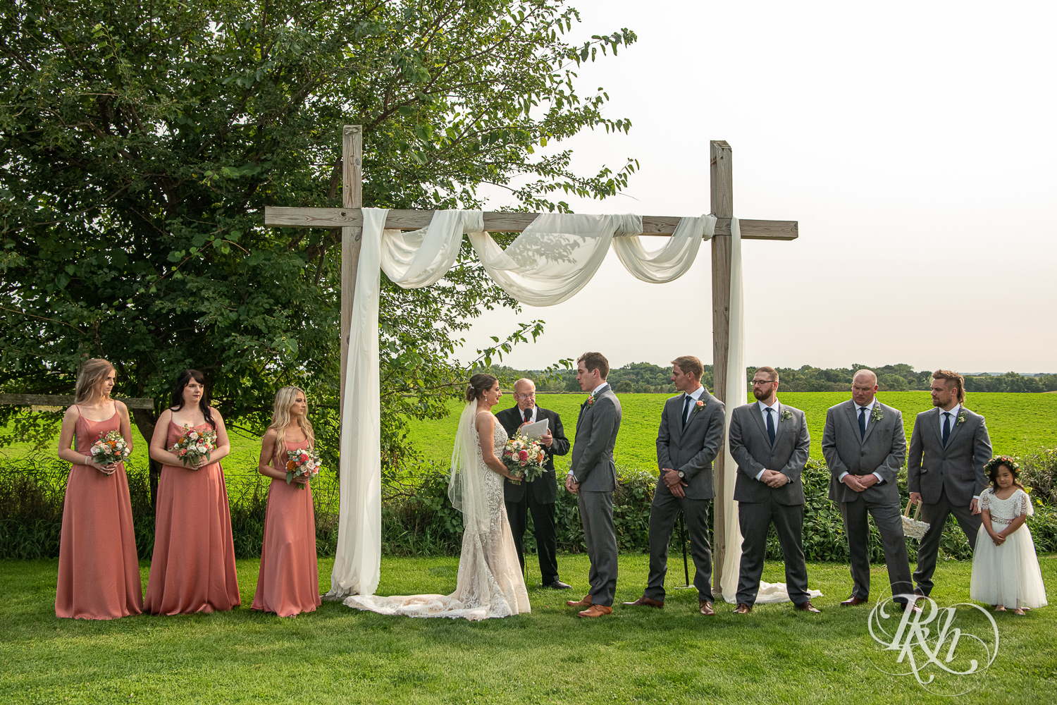 Bride and groom smile during wedding ceremony at Legacy Hills Farm in Welch, Minnesota.
