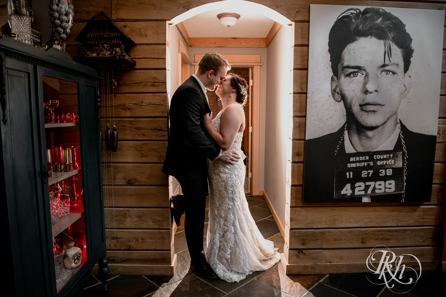 Bride and groom smile in the hallway at a cabin A-frame in Stillwater, Minnesota.