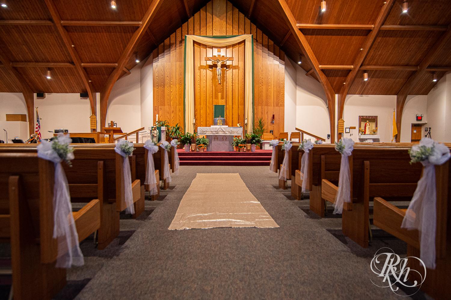 Wide shot of a church wedding ceremony with white flowers in Stillwater, Minnesota.