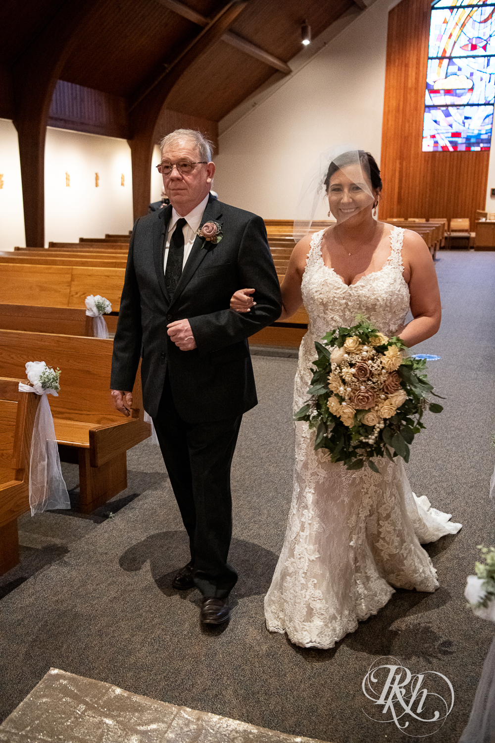 Bride walks down the aisle at a church wedding ceremony in Stillwater, Minnesota.