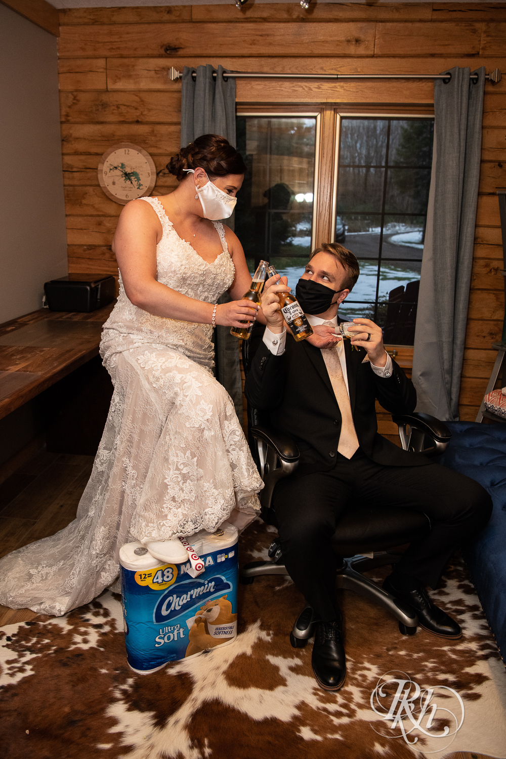 Bride and groom share Coronas and wear masks at 2020 wedding in cabin in Stillwater, Minnesota.