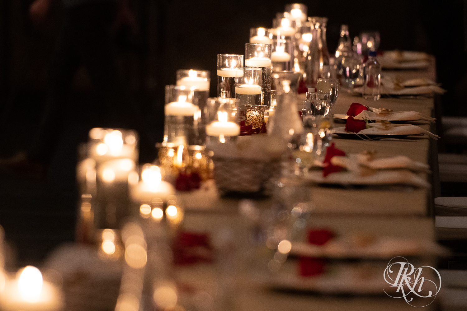 Indoor wedding reception with red roses and candles at Aria in Minneapolis, Minnesota.