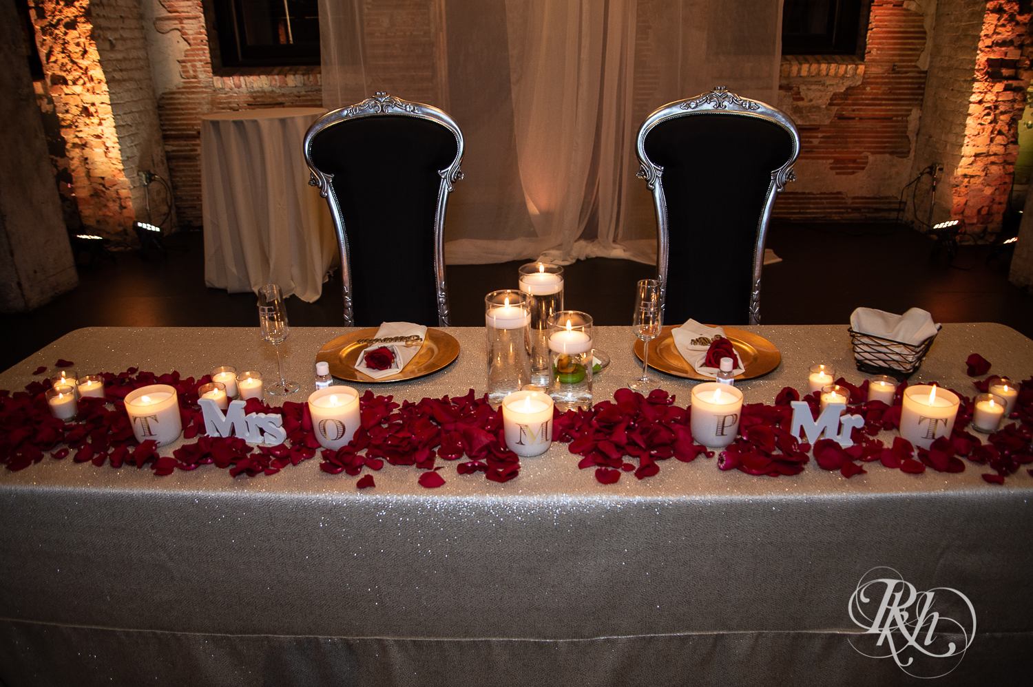 Indoor wedding reception with red roses and candles at Aria in Minneapolis, Minnesota.