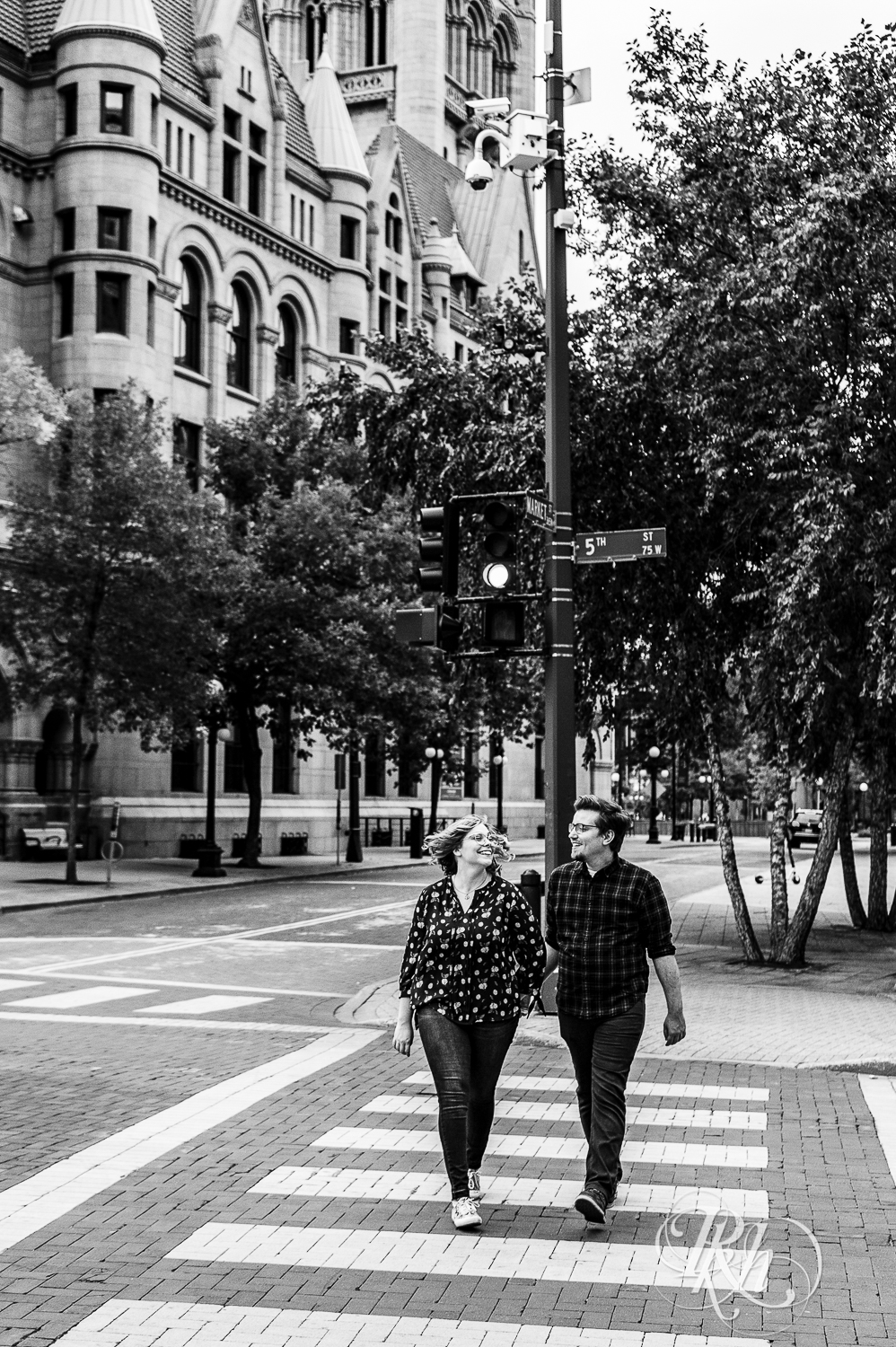 Blond woman with glasses and man with glasses walk across the street in Saint Paul, Minnesota.