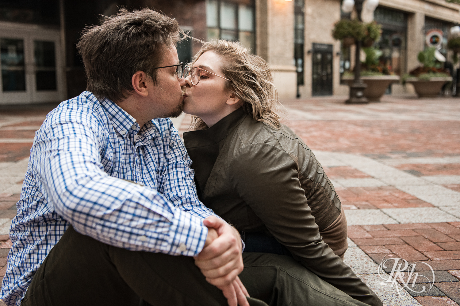 Blond woman with glasses and man with glasses kiss in front of the Palace Theater in Saint Paul, Minnesota.