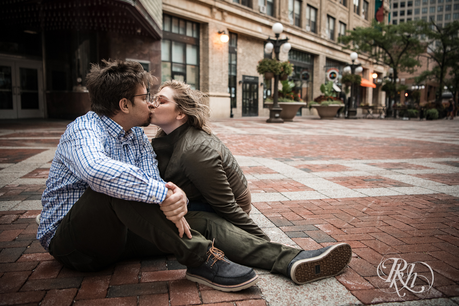Blond woman with glasses and man with glasses kiss in front of the Palace Theater in Saint Paul, Minnesota.