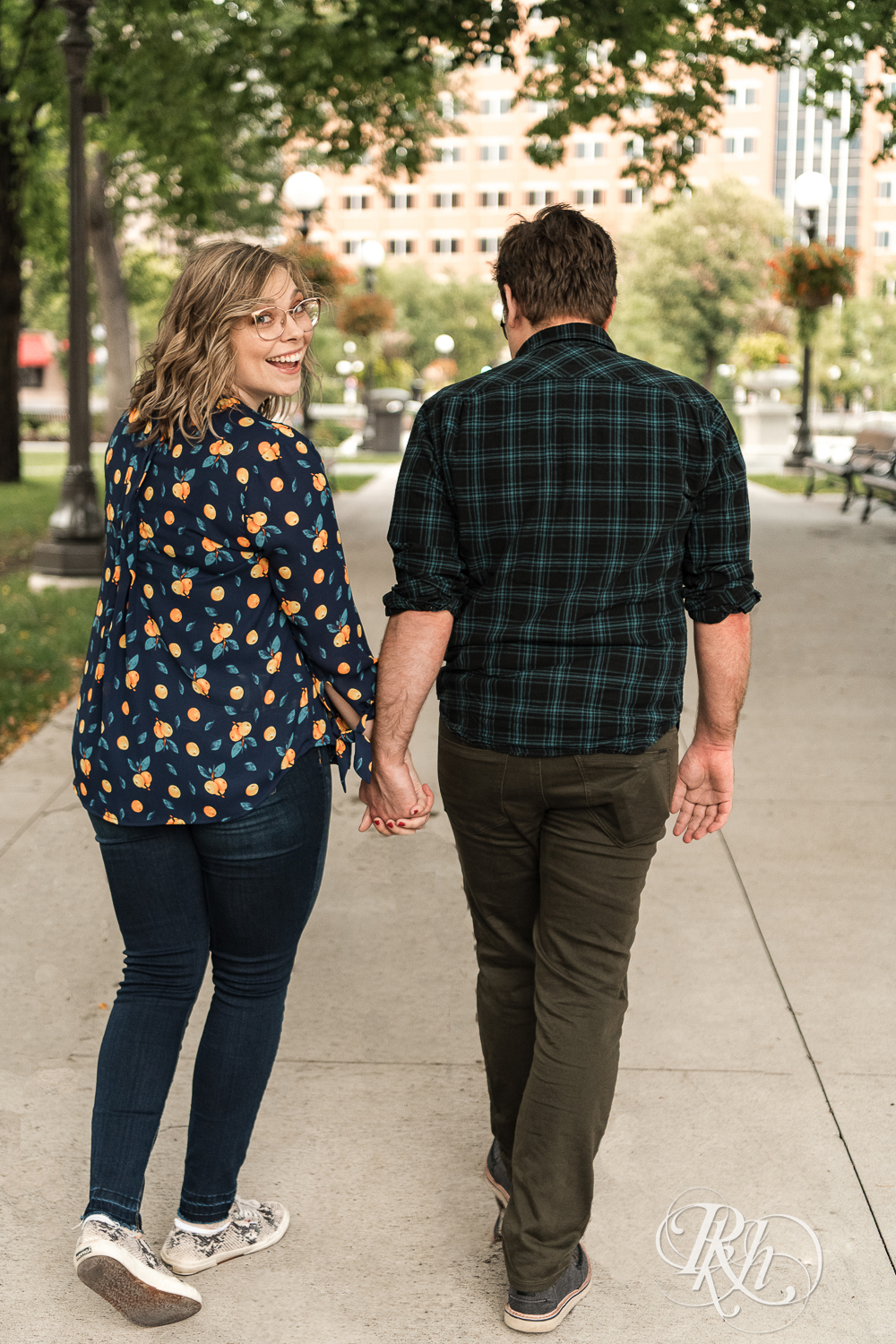 Blond woman with glasses and man with glasses walk on sidewalk in Saint Paul, Minnesota.