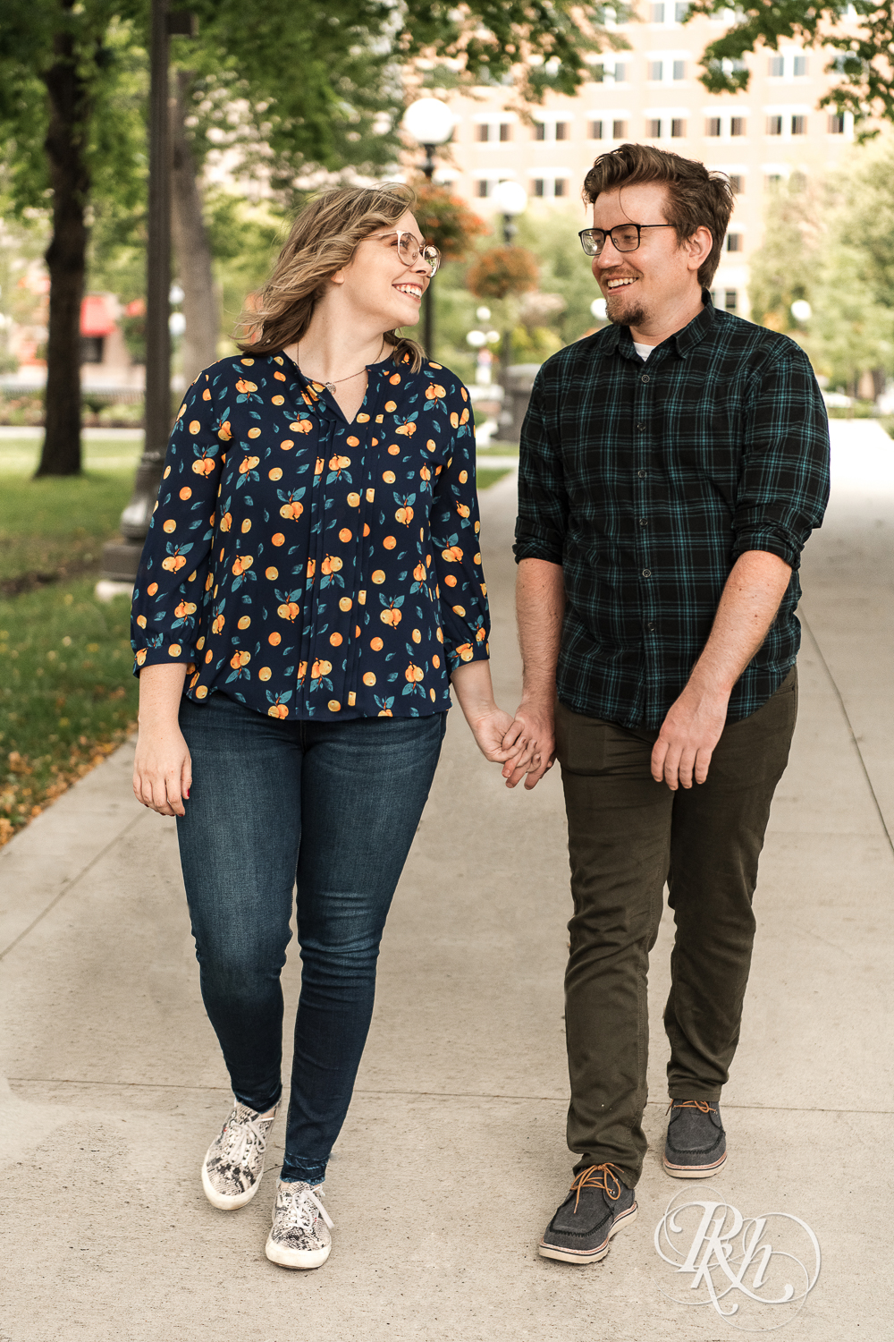 Blond woman with glasses and man with glasses walk on sidewalk in Saint Paul, Minnesota.