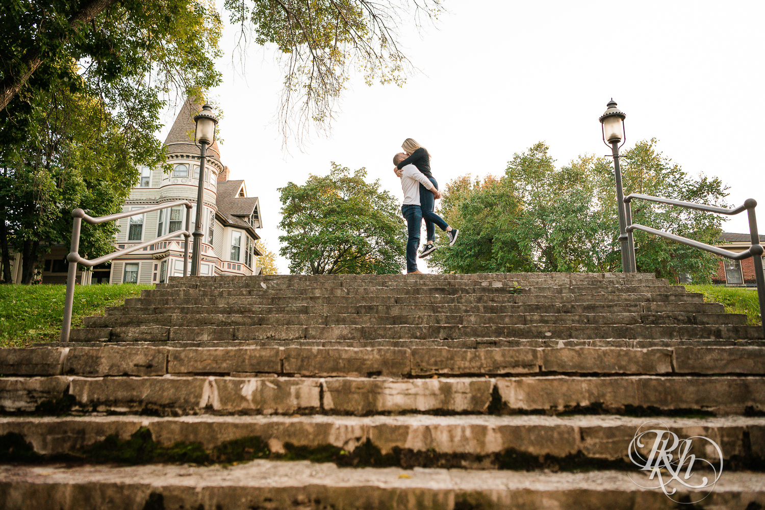 Man lifts and kisses woman at the top of the stairs at Irvine Park in Saint Paul, Minnesota.