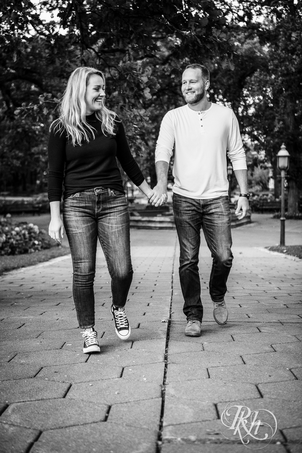 Blonde man and woman in sweaters and jeans walk through Irvine Park in Saint Paul, Minnesota.