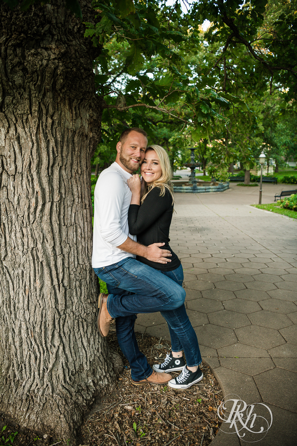 Blonde man and woman in sweaters and jeans walk smile in Irvine Park in Saint Paul, Minnesota.