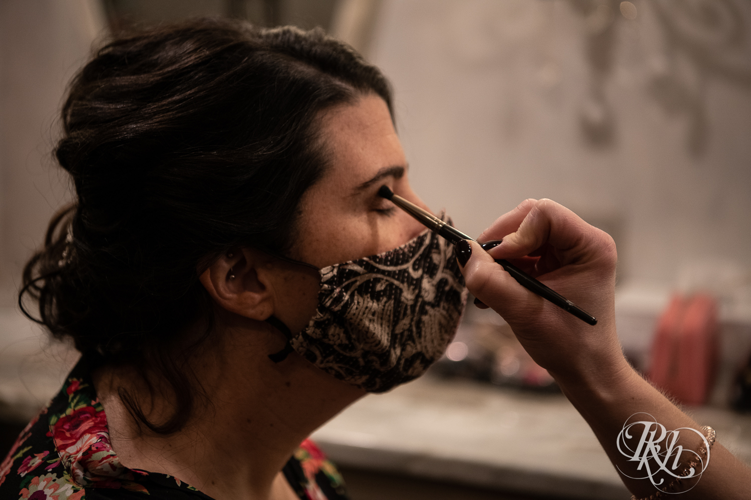 Bride getting makeup done wearing a mask at Minneapolis Event Center in Minneapolis, Minnesota.
