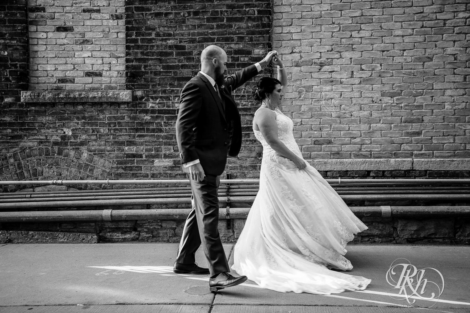 Bride and groom dance in the alley in Saint Anthony Main in Minneapolis, Minnesota.