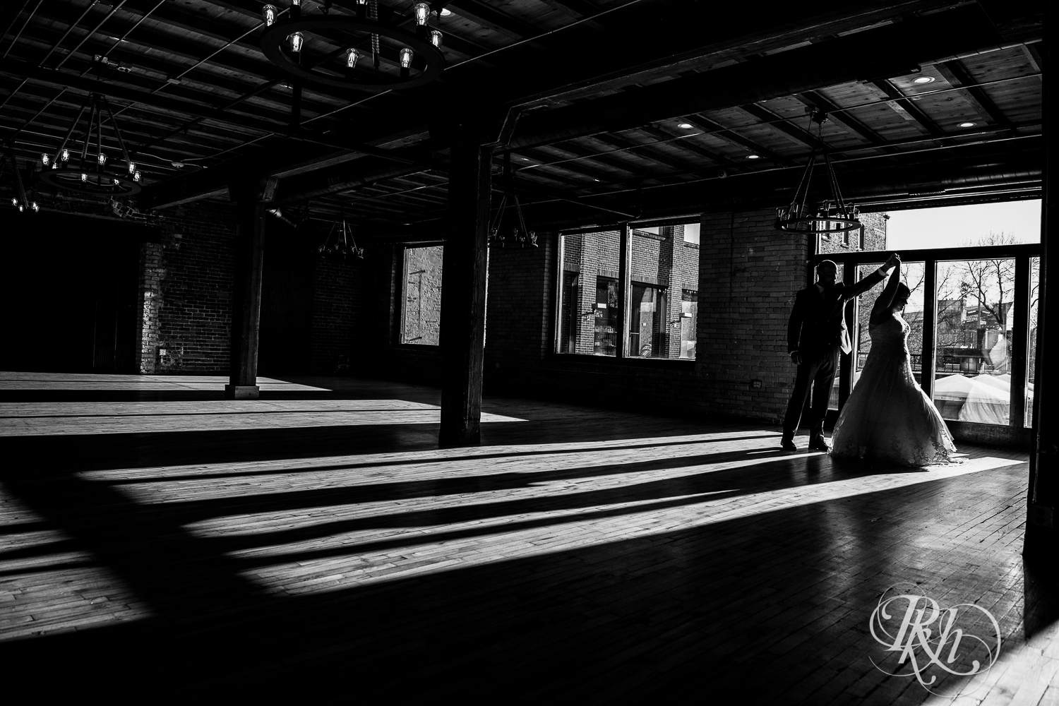 Bride and groom dance in silhouette in Minneapolis Event Centers in Minneapolis, Minnesota.