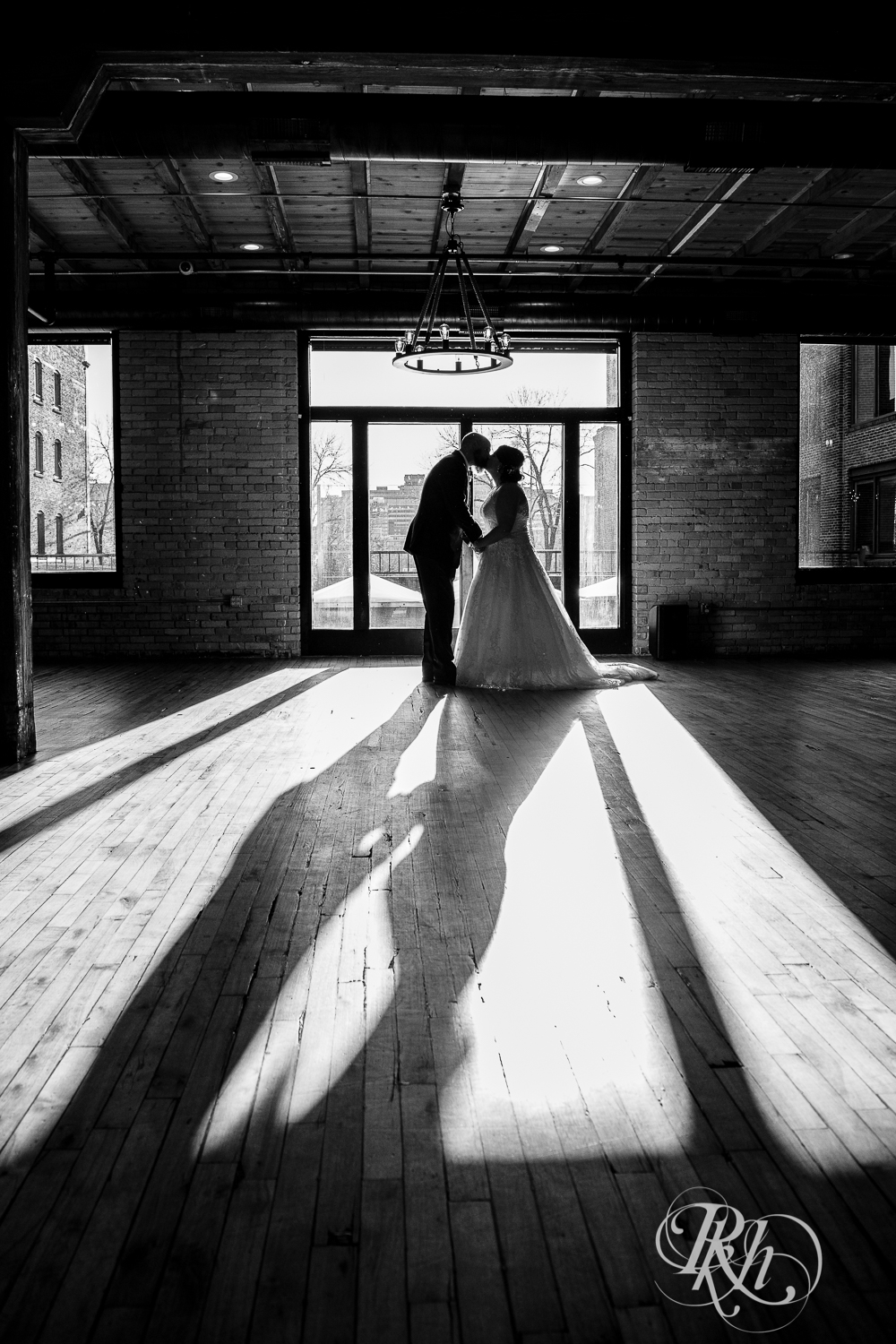 Bride and groom kiss in silhouette in Minneapolis Event Centers in Minneapolis, Minnesota.
