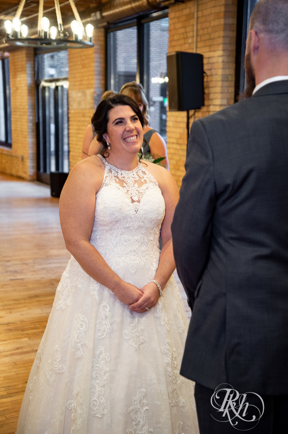 Bride and groom smile during wedding ceremony at Minneapolis Event Centers in Minneapolis, Minnesota.